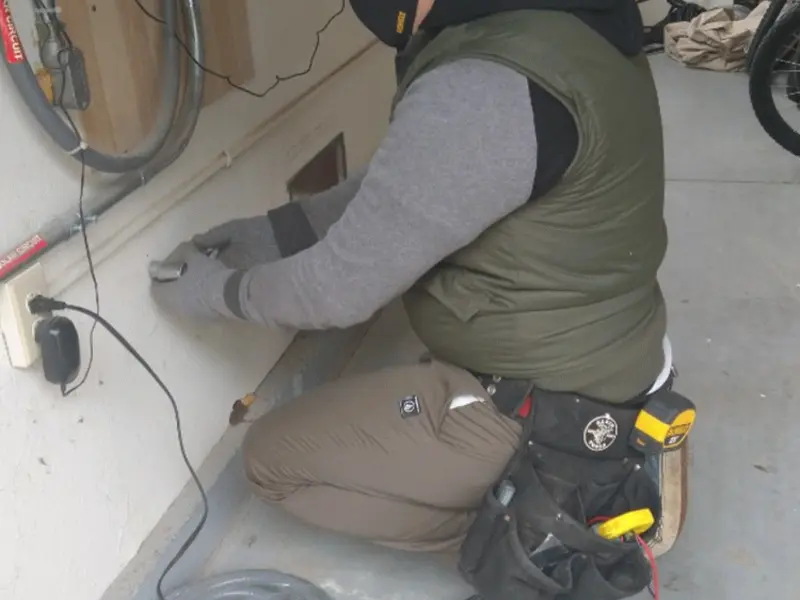 Electrician performing outlet wiring in a Vinton garage